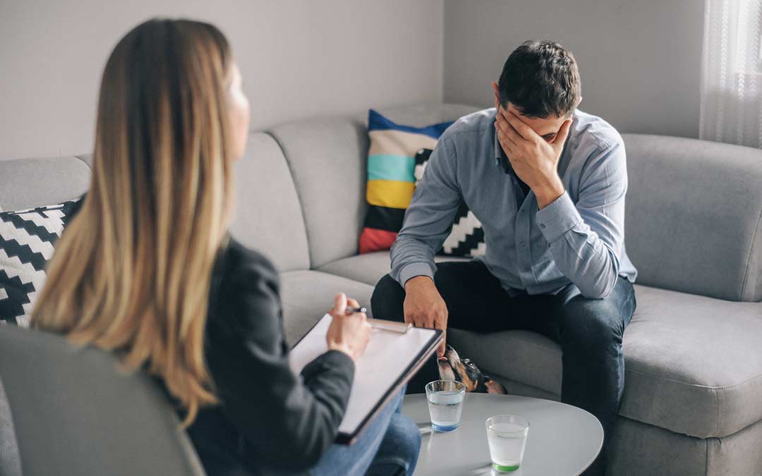 man in a therapy session with long-haired therapist