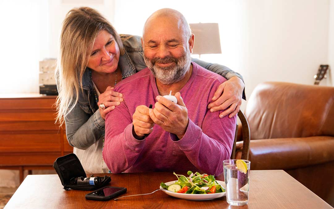 women helps a mature man monitor his diabetes