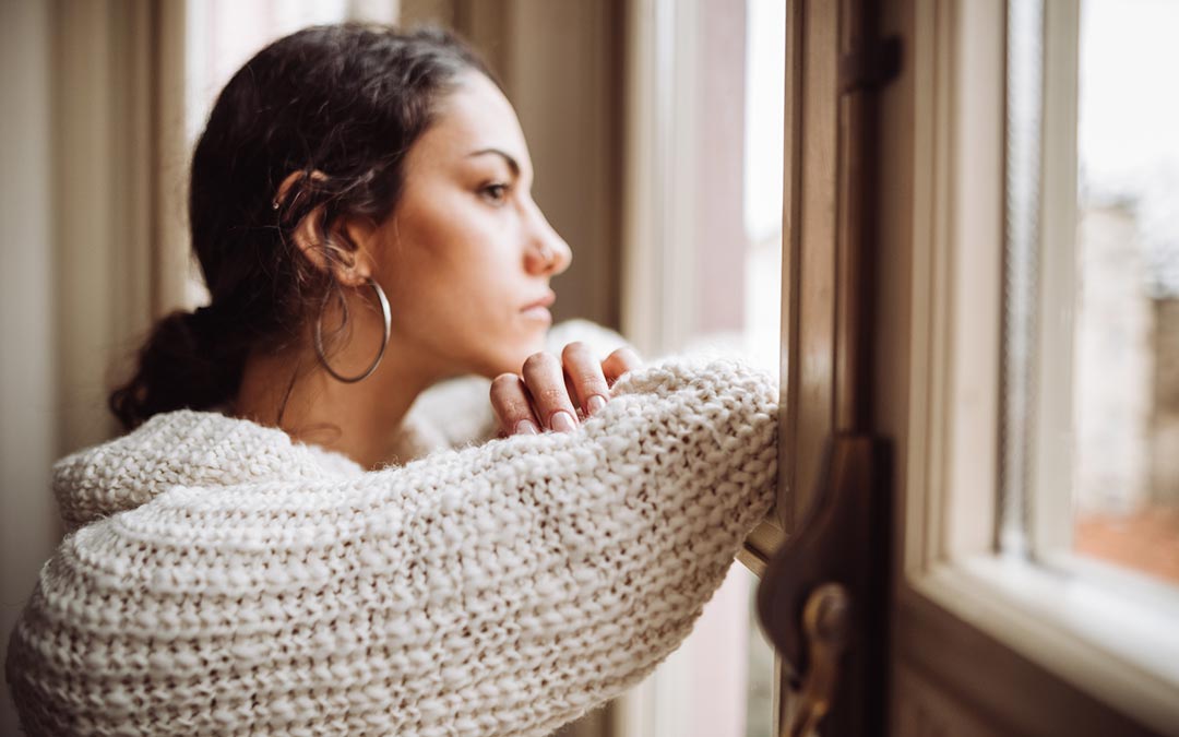 pensive young woman in front of the window