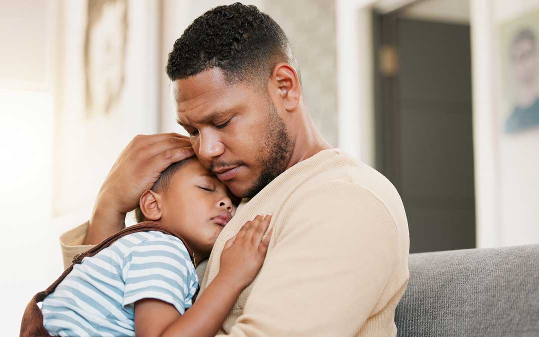 man holds sleeping child